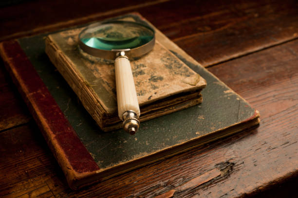 retro old books with optical magnifying glass on old wooden table