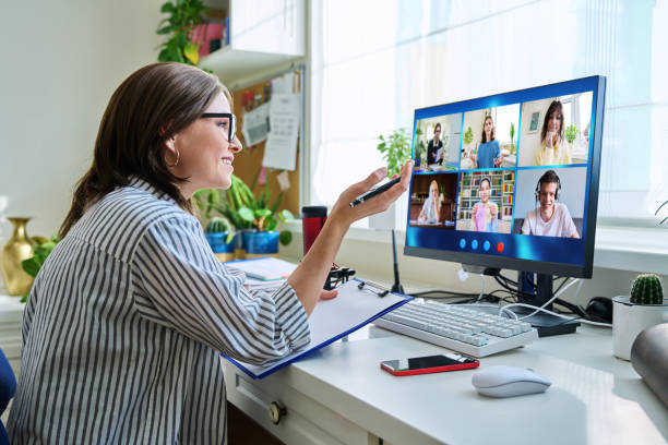 Female teacher working at home remotely, online lesson with group teenage students, teaching looking at computer screen sitting at home. Distance virtual class course interactive lesson video conference.